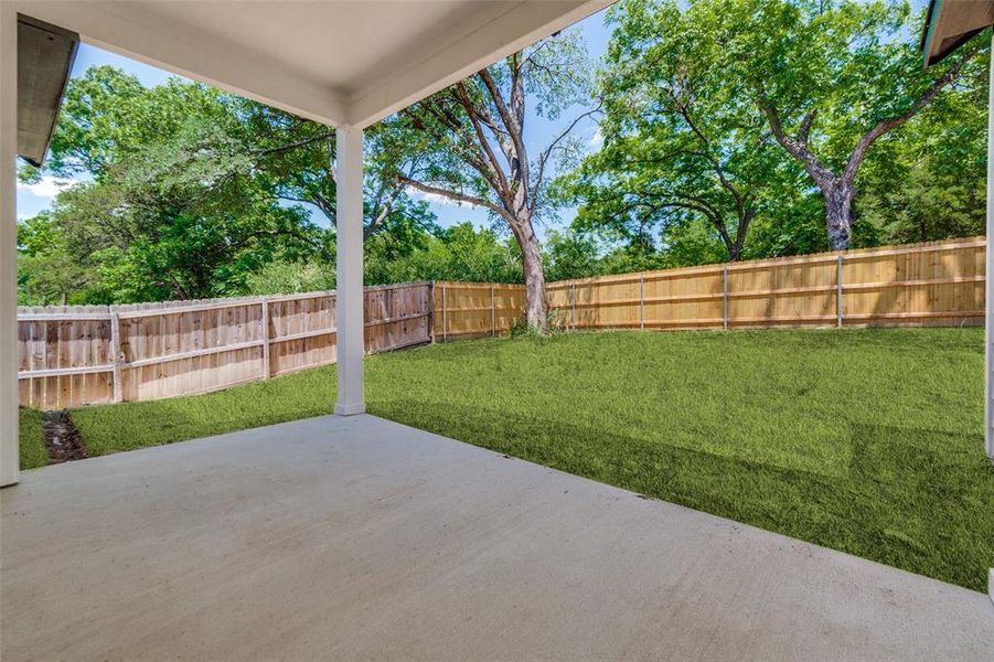 Covered concrete patio opening to a spacious grassy yard Covered concrete patio opening to a spacious grassy yard