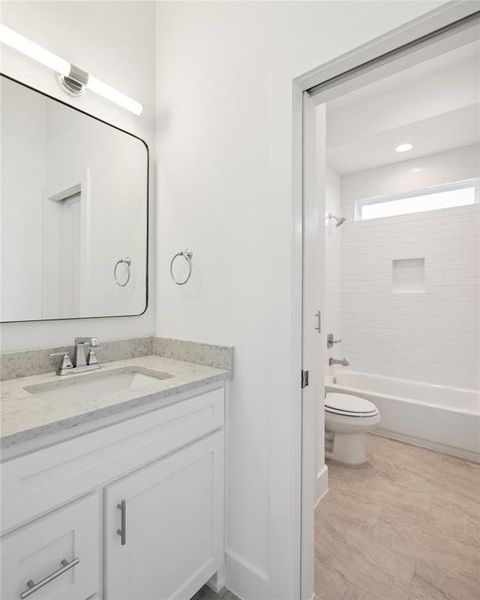 Full bathroom featuring tiled shower / bath, toilet, and vanity