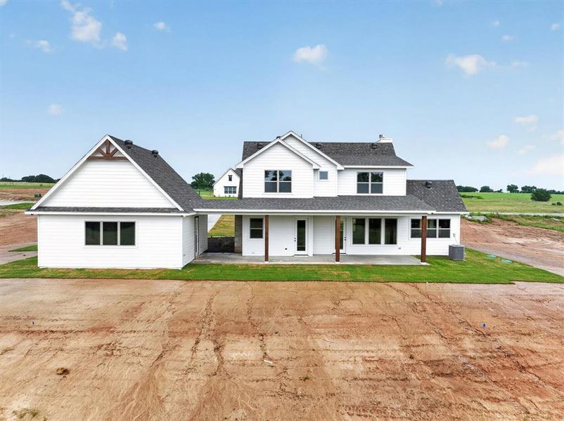 Modern farmhouse architecture featuring white siding and dark shingle roofing