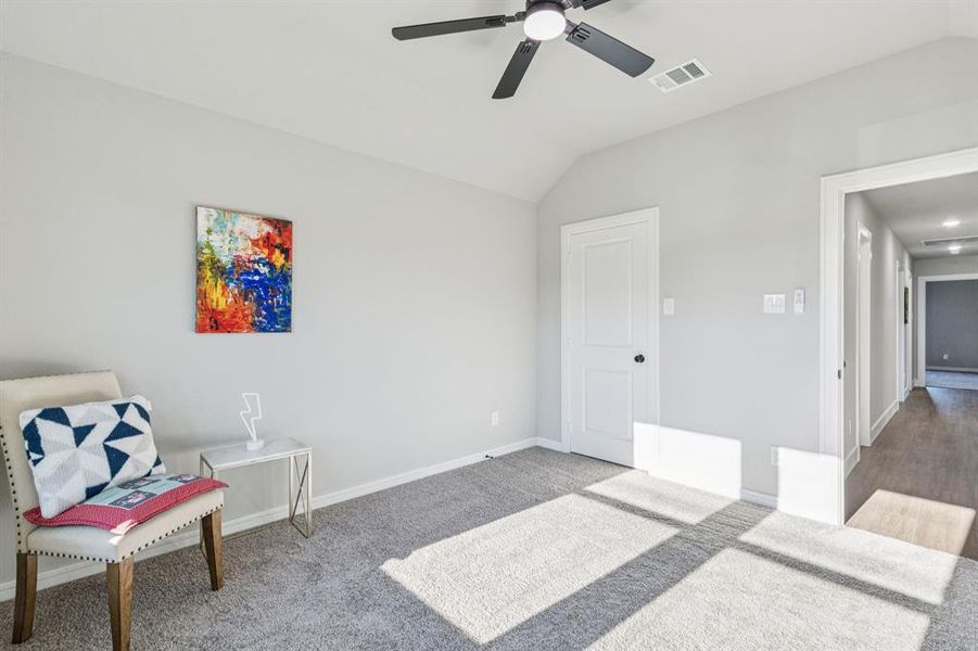 Sitting room featuring vaulted ceiling, carpet, and ceiling fan