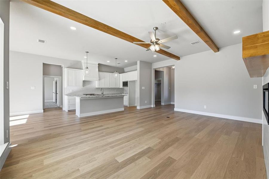 Unfurnished living room with recessed lighting, ceiling fan, light wood-style flooring, and beam ceiling Unfurnished living room with recessed lighting, ceiling fan, light wood-style flooring, and beam ceiling