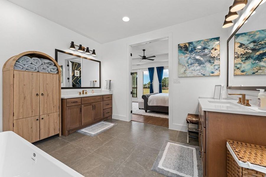 Dual vanities and a deep soaking tub create a luxurious primary bathroom retreat. Dual vanities and a deep soaking tub create a luxurious primary bathroom retreat.