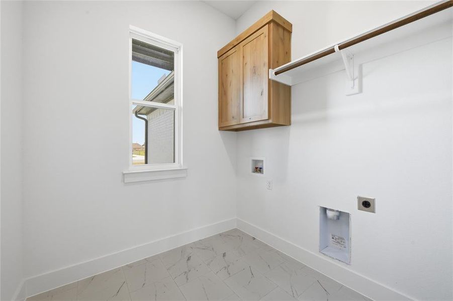 Laundry area with light marble finish floors, cabinet space, hookup for an electric dryer, and hookup for a washing machine Laundry area with light marble finish floors, cabinet space, hookup for an electric dryer, and hookup for a washing machine
