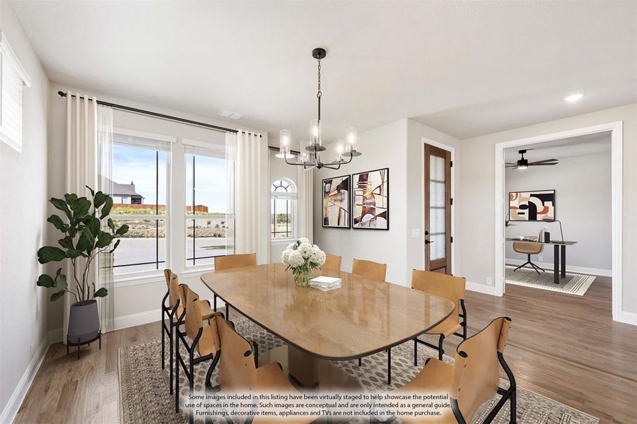 Dining room with large wood table, eight chairs, chandelier, and sliding glass doors with natural light