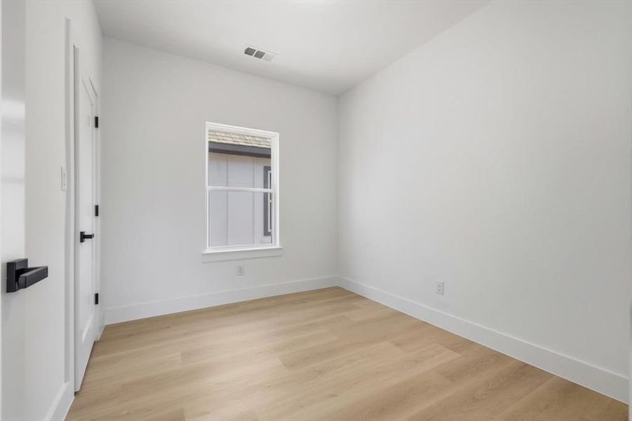 Bedroom with light wood-style flooring and baseboards