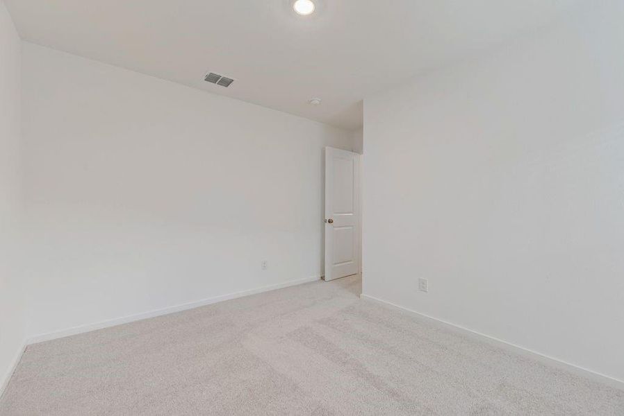 Spare room featuring carpet flooring and baseboards
