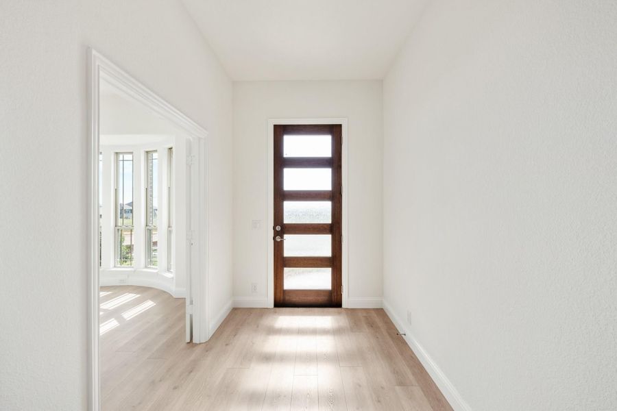 Entryway with dark wood front door featuring glass panels and light hardwood floors