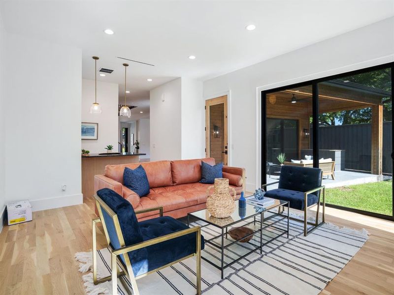Living area with light wood finished floors and recessed lighting