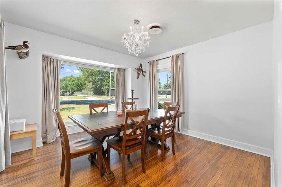Dining space featuring wood-type flooring and a chandelier Dining space featuring wood-type flooring and a chandelier