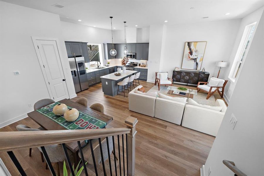 Open-concept kitchen, living, and dining area with modern design, abundant natural light, and stylish finishes for seamless entertaining and comfort.