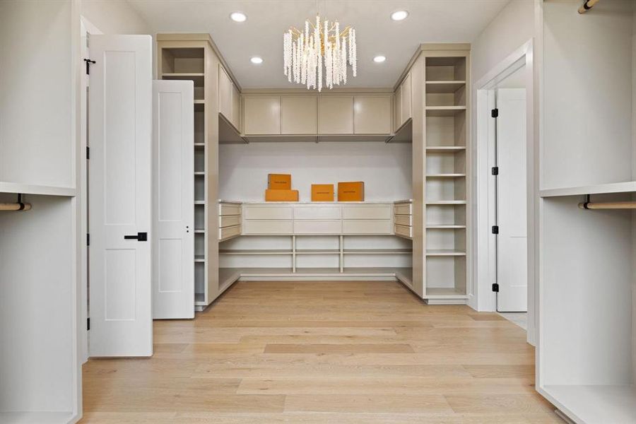Spacious closet with a chandelier and light wood
finished floors Spacious closet with a chandelier and light wood
finished floors