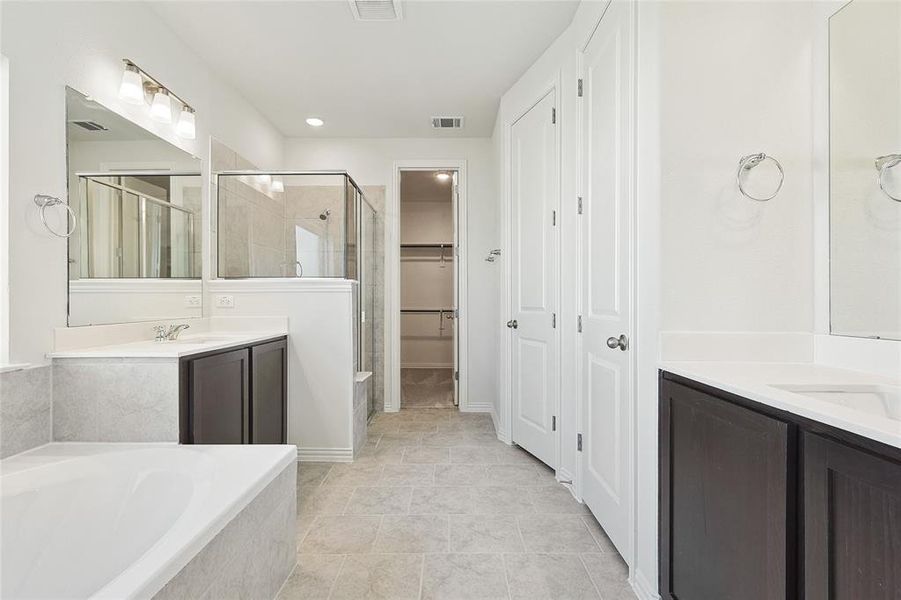 Bathroom with tile floors, plus walk in shower, and vanity with extensive cabinet space