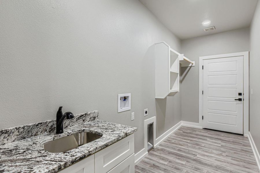 Laundry room featuring hookup for an electric dryer, light wood finished floors, and hookup for a washing machine
