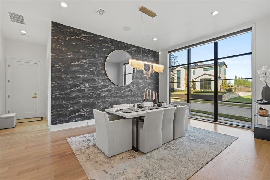 Dining space featuring a wall of windows, recessed lighting, and light wood-type flooring Dining space featuring a wall of windows, recessed lighting, and light wood-type flooring