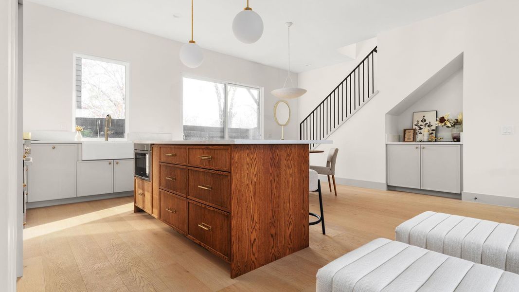 Kitchen with a center island, brown cabinets, a breakfast bar, and light wood-type flooring