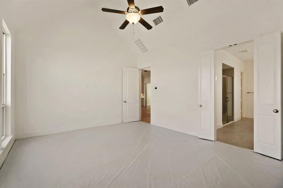 Unfurnished bedroom featuring ceiling fan and lofted ceiling