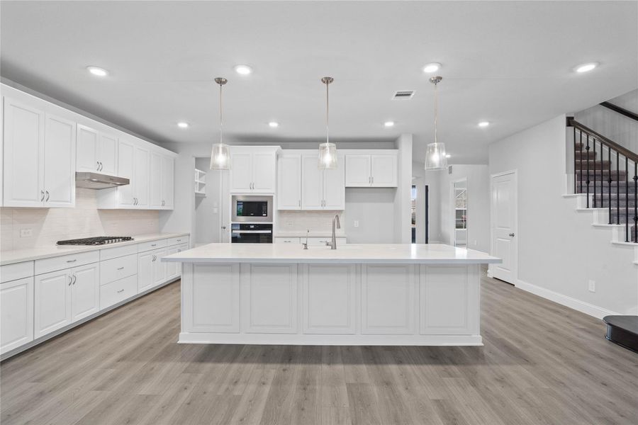 Grand view of this stunning gourmet kitchen serves as the true heart of the home. Its open-concept layout seamlessly connects to the living spaces for effortless entertaining.