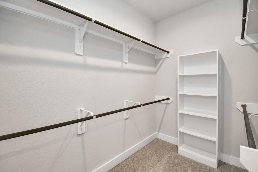 Walk-in closet that epitomizes luxury and practicality. This generously sized space features built-in shelving, offering abundant room for impeccable organization. High ceilings and recessed lighting create a bright and welcoming ambiance. Sample photo of completed home with similar floor plan. Actual colors and selections may vary. Walk-in closet that epitomizes luxury and practicality. This generously sized space features built-in shelving, offering abundant room for impeccable organization. High ceilings and recessed lighting create a bright and welcoming ambiance. Sample photo of completed home with similar floor plan. Actual colors and selections may vary.