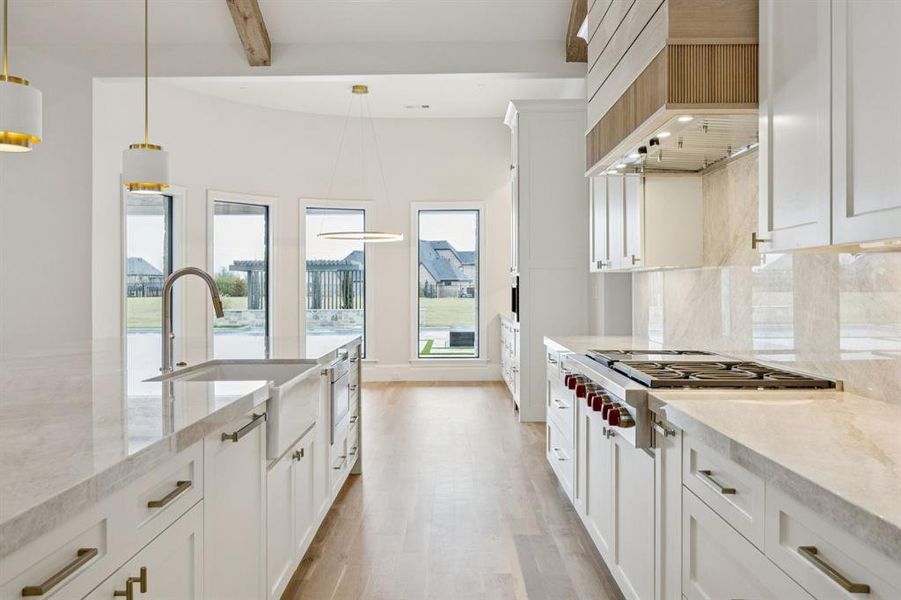 oversized quartzite island with waterfall and complete backsplash and additional 2" miter drop.  Wolf and Thermador appliances