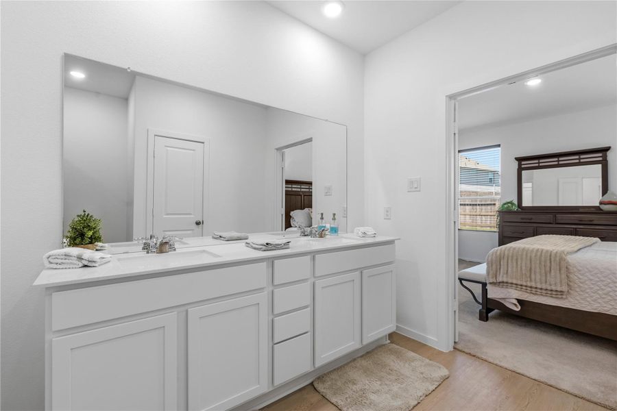 Primary bathroom with double vanity and modern finishes.