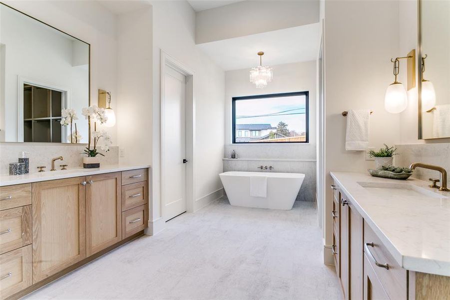 His and her vanities, large soaking tub, elegant lighting, beautiful countertops create a spa-like feel in this primary bath. His and her vanities, large soaking tub, elegant lighting, beautiful countertops create a spa-like feel in this primary bath.