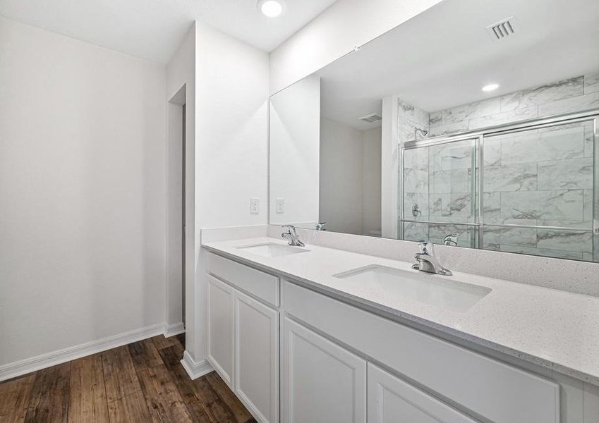 The master bathroom has a double sink vanity and a walk in shower