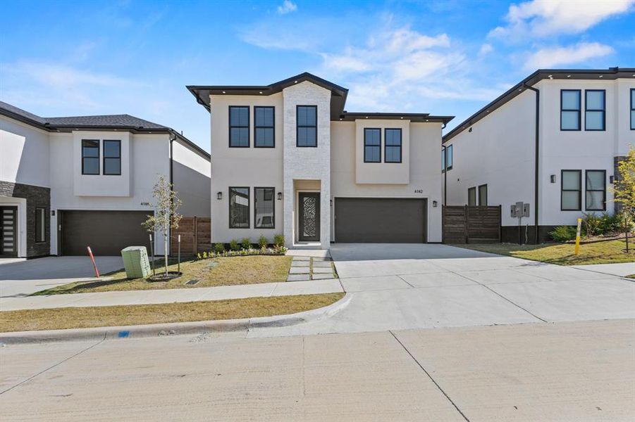 Contemporary house with stucco siding, driveway, and an attached garage