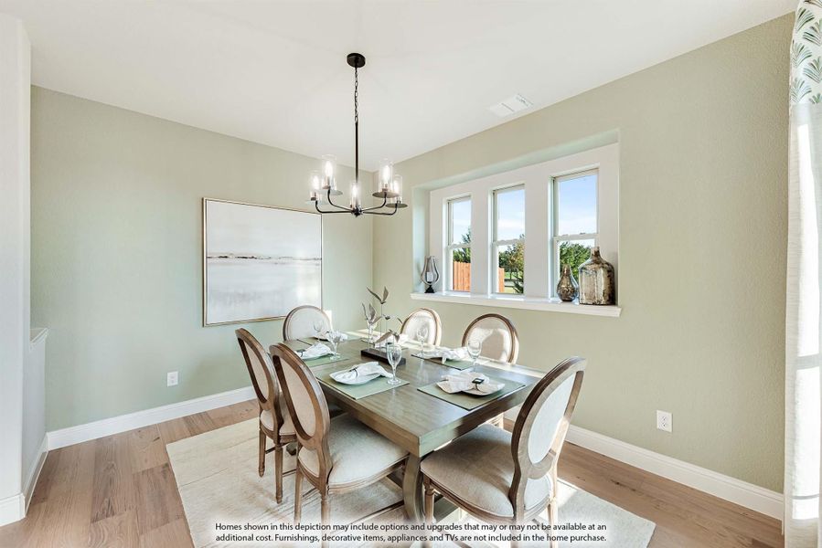 Dining room with six-chair wooden table, chandelier, and hardwood floors with sage green walls