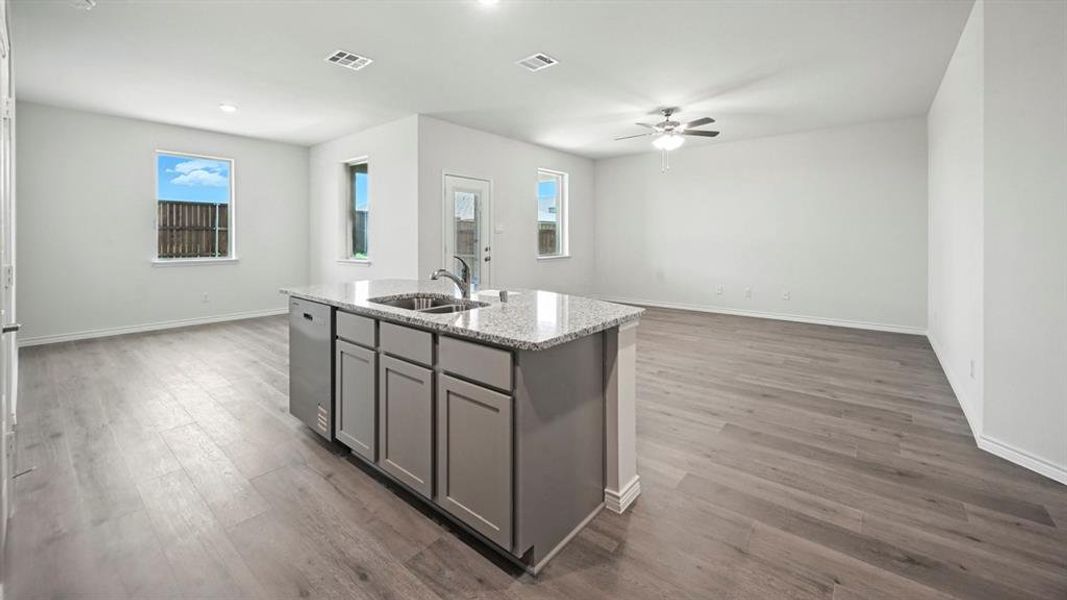 Expansive open-concept living area featuring wood-finish flooring and a central kitchen island