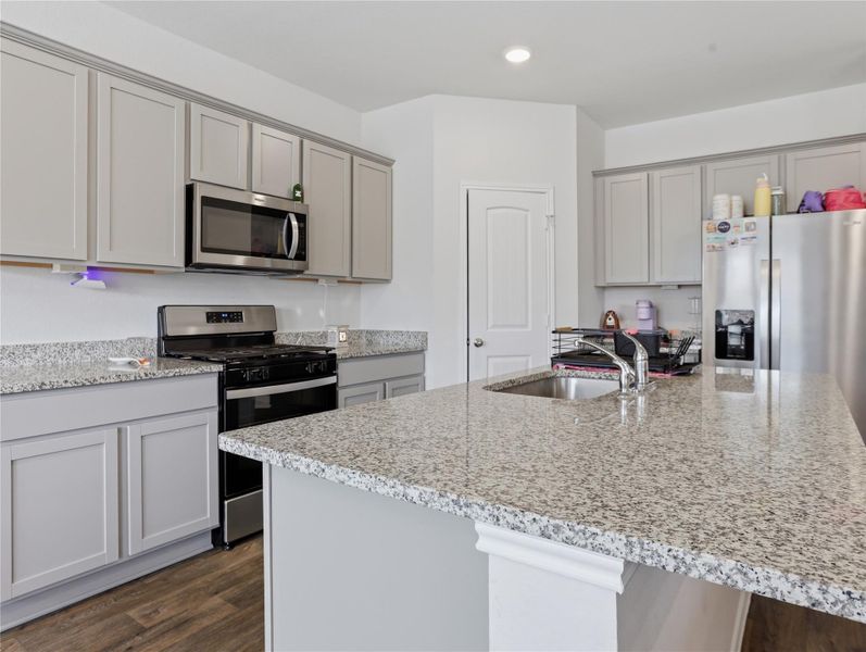 Gleaming granite countertops pair with recessed lighting and beautiful wood floors in this modern workspace. Gleaming granite countertops pair with recessed lighting and beautiful wood floors in this modern workspace.