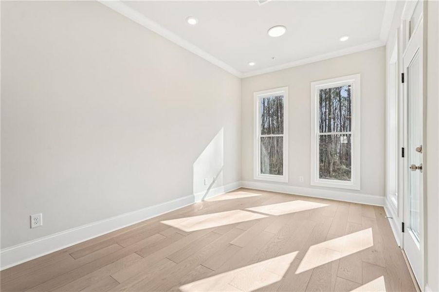 Unfurnished room featuring light wood-type flooring, ornamental molding, and recessed lighting