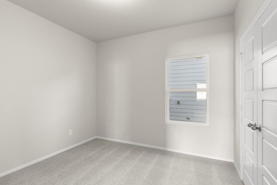 Image of a bedroom with light grey walls, tan carpeting, and a window with white trim Image of a bedroom with light grey walls, tan carpeting, and a window with white trim