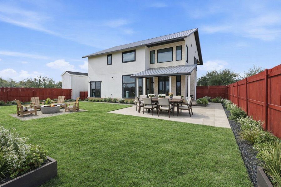 Rear view of property featuring a patio area, a fenced backyard, an outdoor fire pit, stucco siding, and outdoor dining space