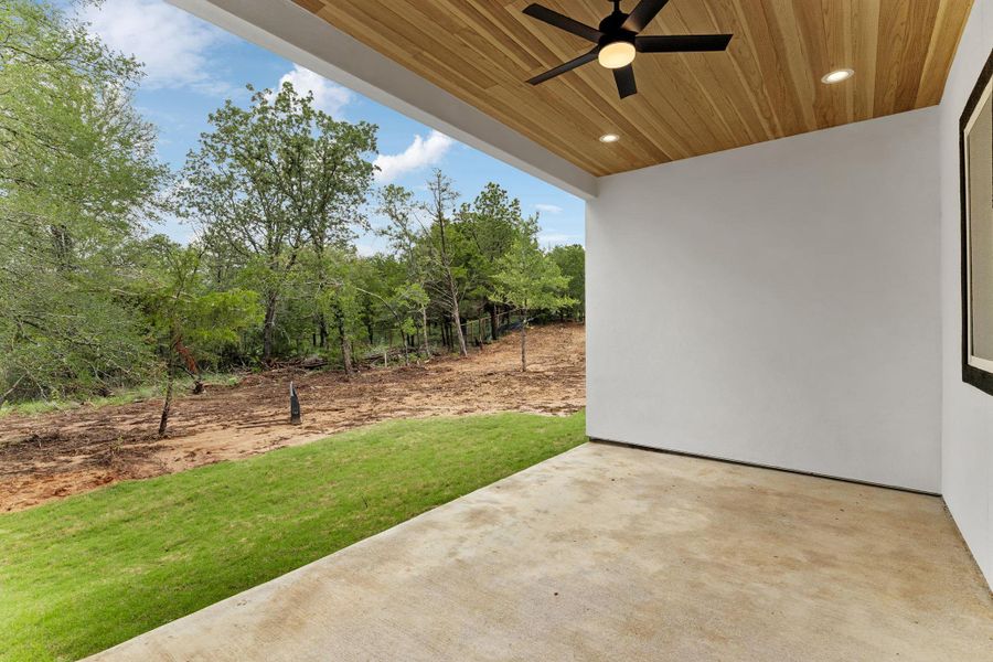 A spacious covered patio offers a refreshing outdoor retreat with natural views.