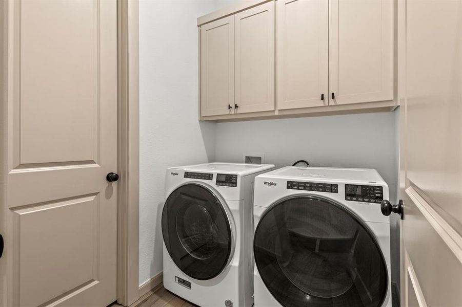 Laundry area with cabinet space and washer and clothes dryer