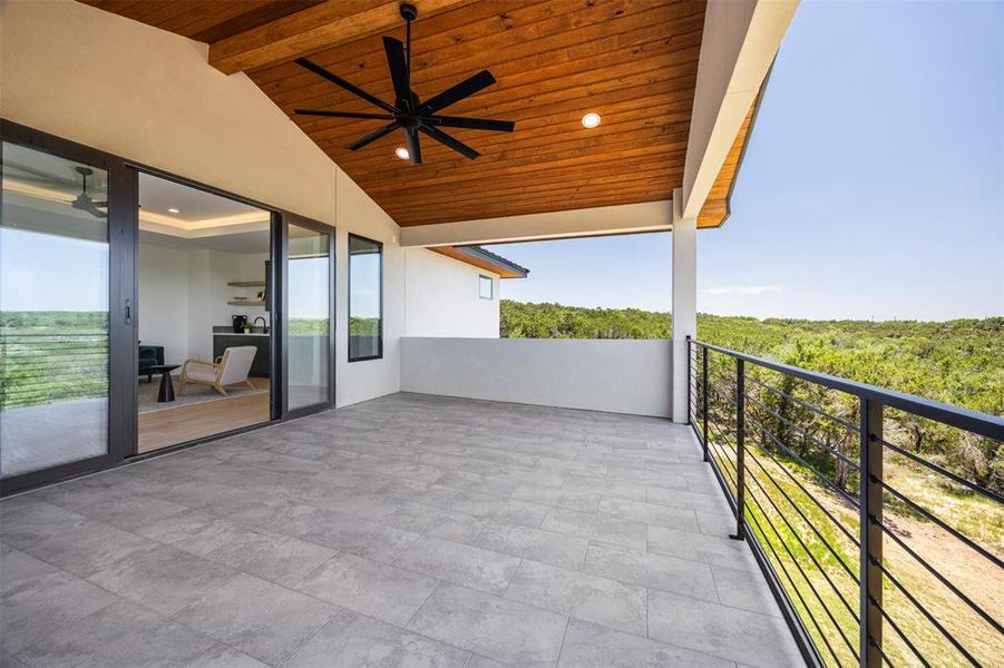 A spacious outdoor deck with wood plank ceilings and an amazing view of Lake Travis.