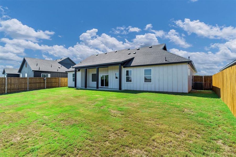 Rear view of property with a lawn