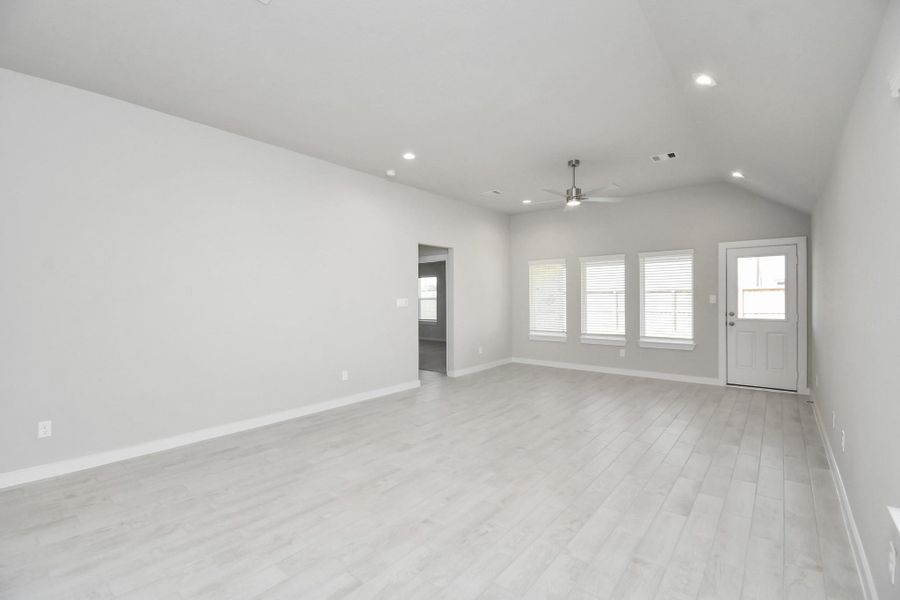 Gather the family and guests together in your lovely living room! Featuring soaring high ceilings, recessed lighting, ceiling fan, custom paint, gorgeous floors, and large windows that provide plenty of natural lighting throughout the day. Sample photo of completed home with similar floor plan. Actual colors and selections may vary.