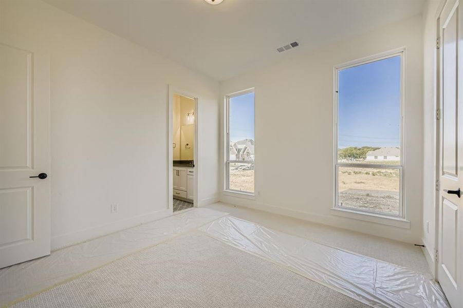 Unfurnished bedroom featuring carpet and connected bathroom Unfurnished bedroom featuring carpet and connected bathroom