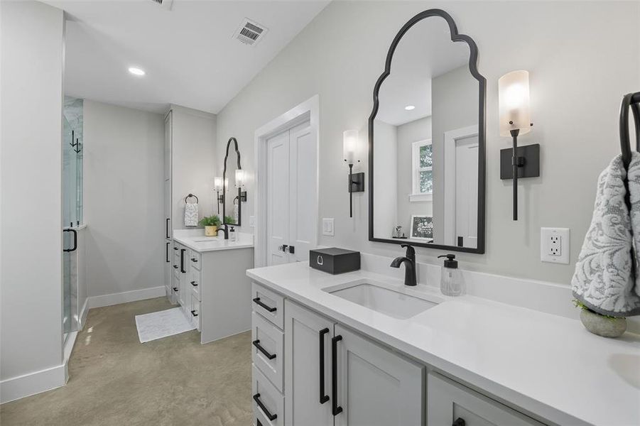 Bathroom featuring concrete flooring, two vanities, a shower stall, and recessed lighting Bathroom featuring concrete flooring, two vanities, a shower stall, and recessed lighting