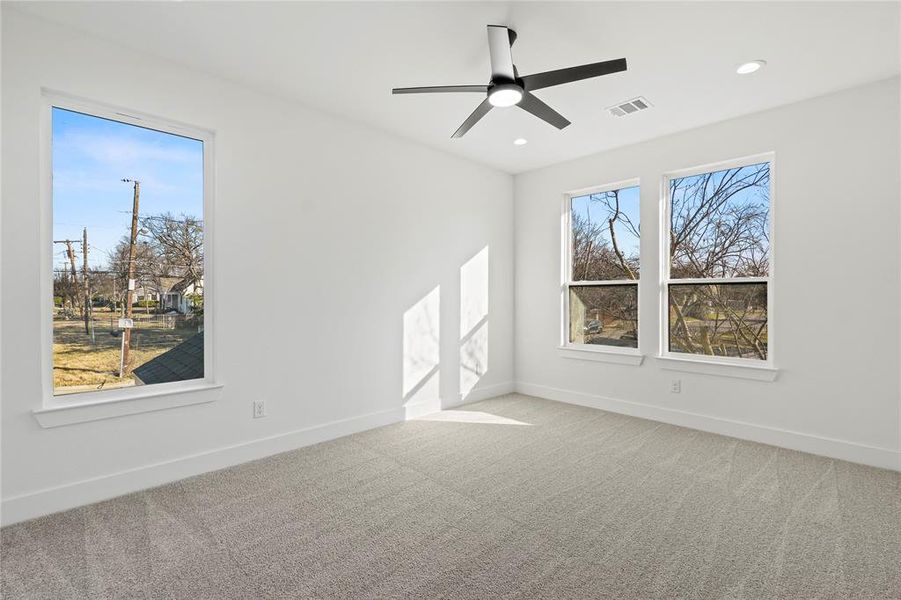 Spare room featuring light colored carpet, ceiling fan, and recessed lighting