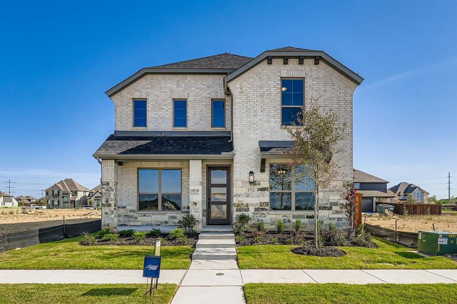 View of front of property with roof with shingles and brick siding