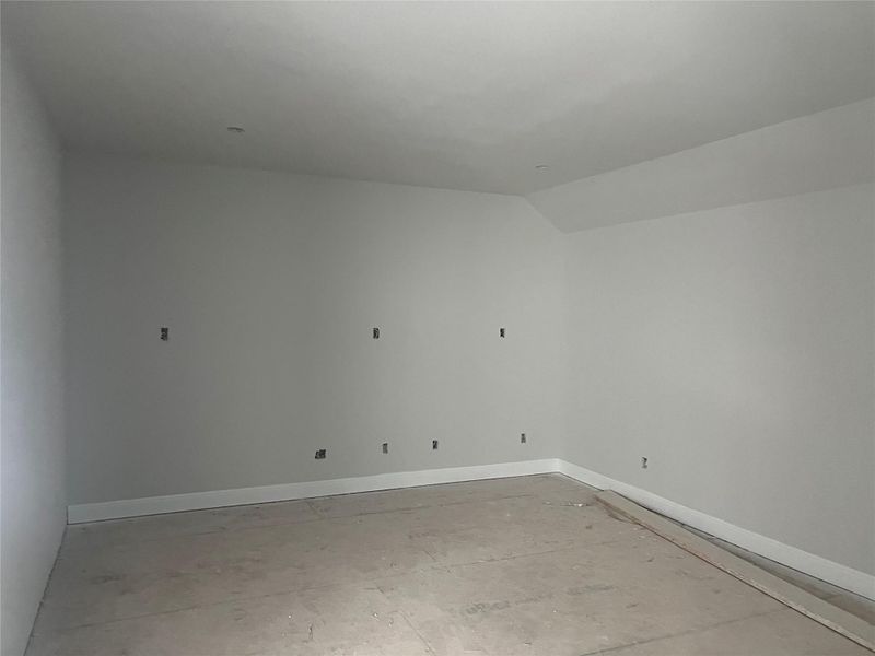 Empty room with baseboards and lofted ceiling