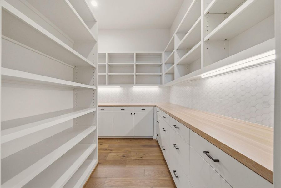 Wonderful walk-in pantry with bountiful storage options and butcher-block countertops.
