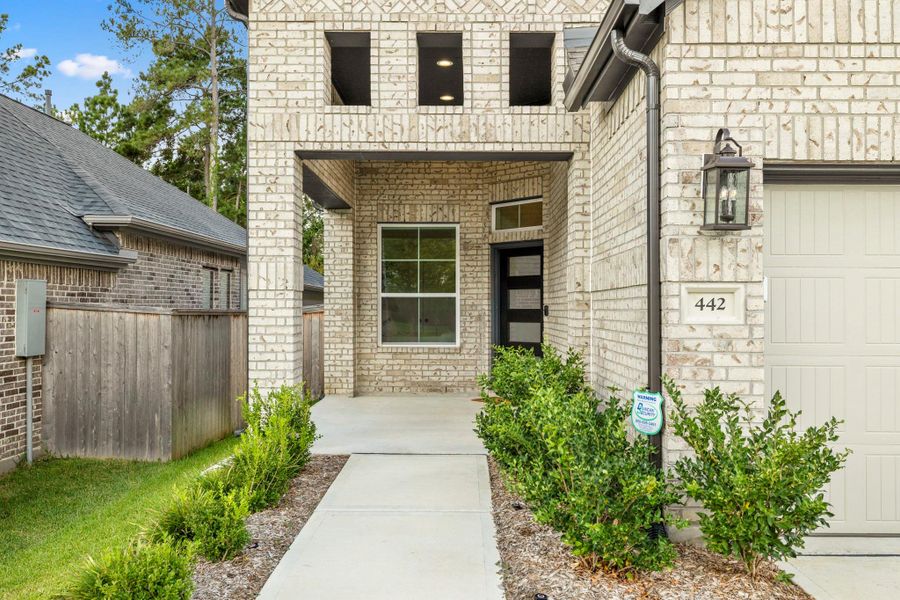 Showcases a charming brick exterior with a covered entryway, modern door, and neatly landscaped path leading to the front entrance. The property features a clean, inviting facade with a visible garage and attractive greenery. Showcases a charming brick exterior with a covered entryway, modern door, and neatly landscaped path leading to the front entrance. The property features a clean, inviting facade with a visible garage and attractive greenery.