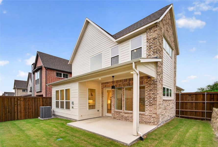 Rear exterior featuring a covered patio, brick and siding facade, multiple windows, and a fenced backyard with grass lawn Rear exterior featuring a covered patio, brick and siding facade, multiple windows, and a fenced backyard with grass lawn