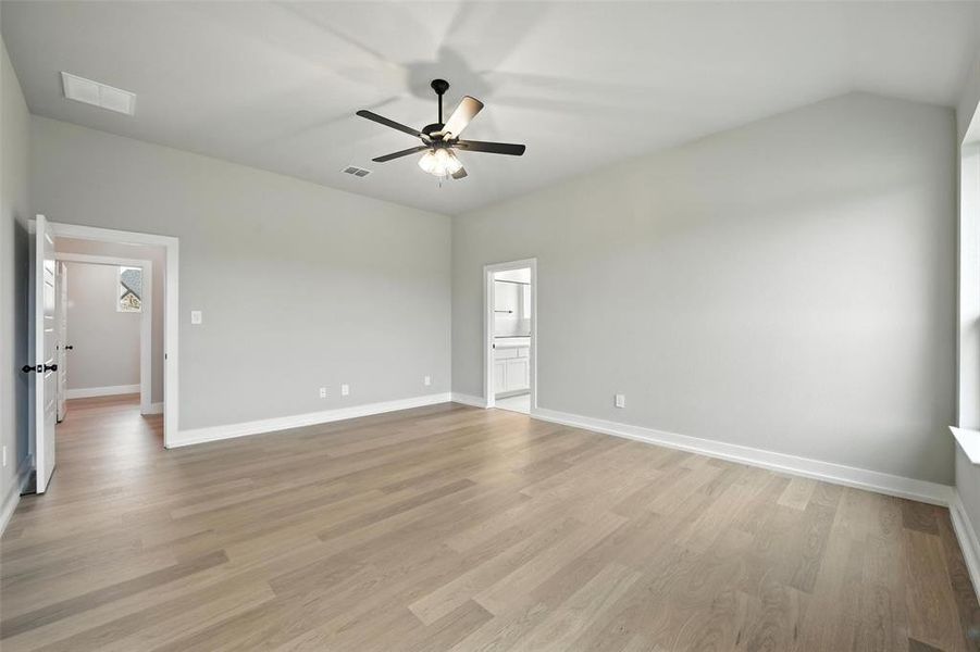 Spare room with ceiling fan, light wood-type flooring, and vaulted ceiling Spare room with ceiling fan, light wood-type flooring, and vaulted ceiling