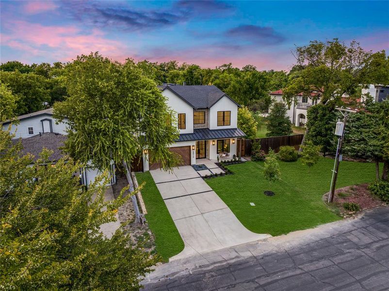 Modern inspired farmhouse featuring covered porch, a standing seam roof, a metal roof, concrete driveway, and an attached garage Modern inspired farmhouse featuring covered porch, a standing seam roof, a metal roof, concrete driveway, and an attached garage