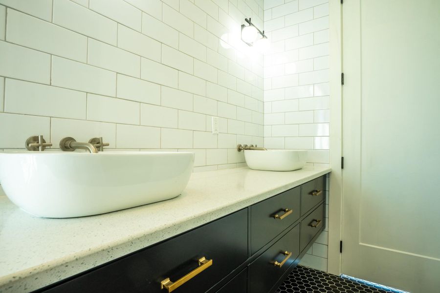 Bathroom featuring vanity and tile walls