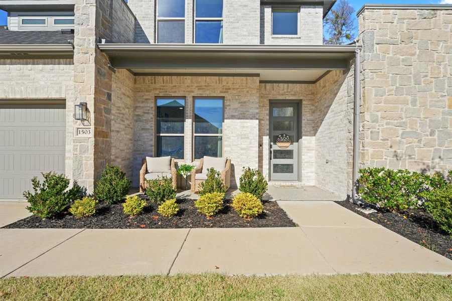Doorway to property featuring a porch and brick siding